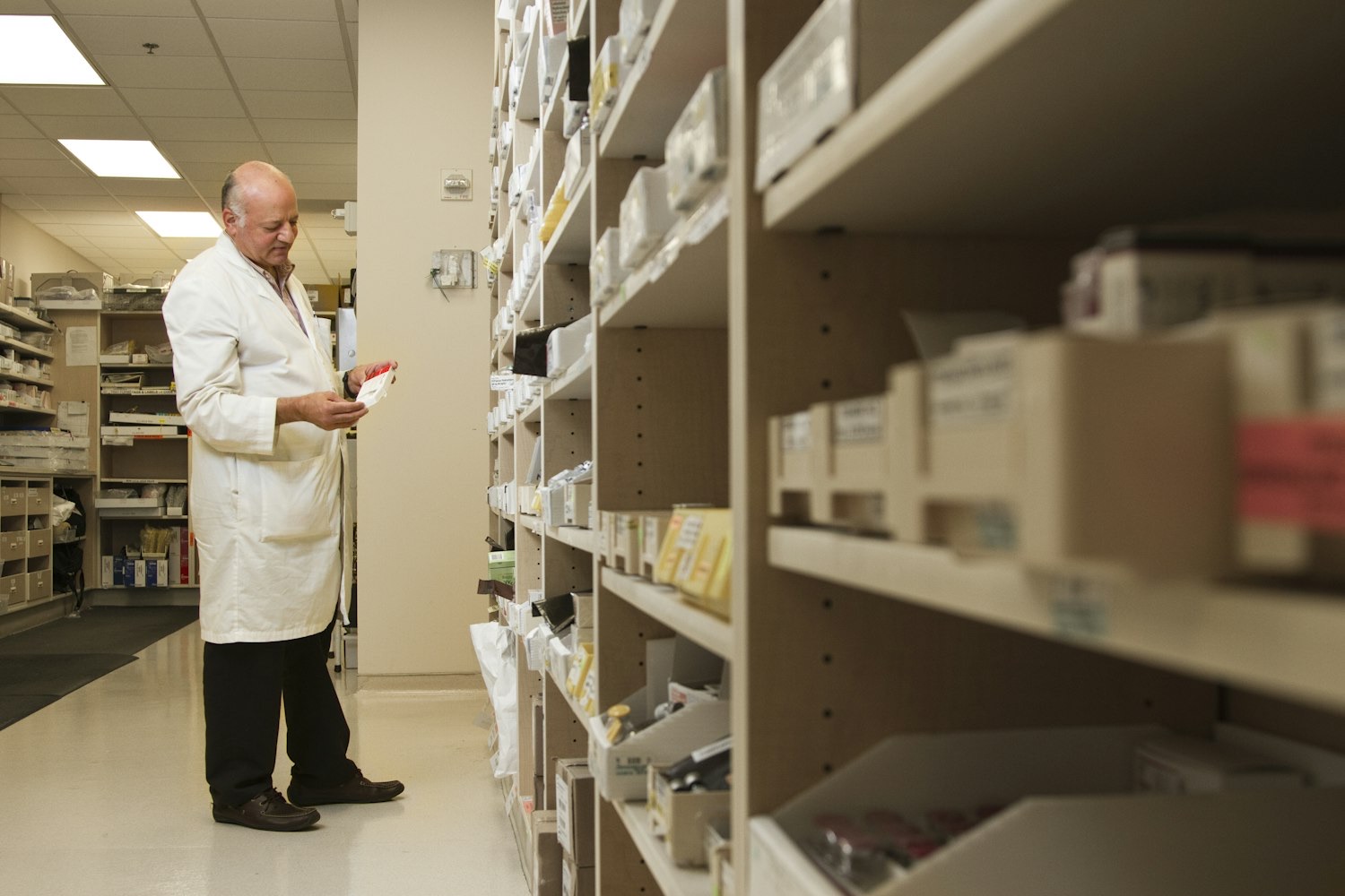Inside a modern retail pharmacy, a pharmacist filling a prescription